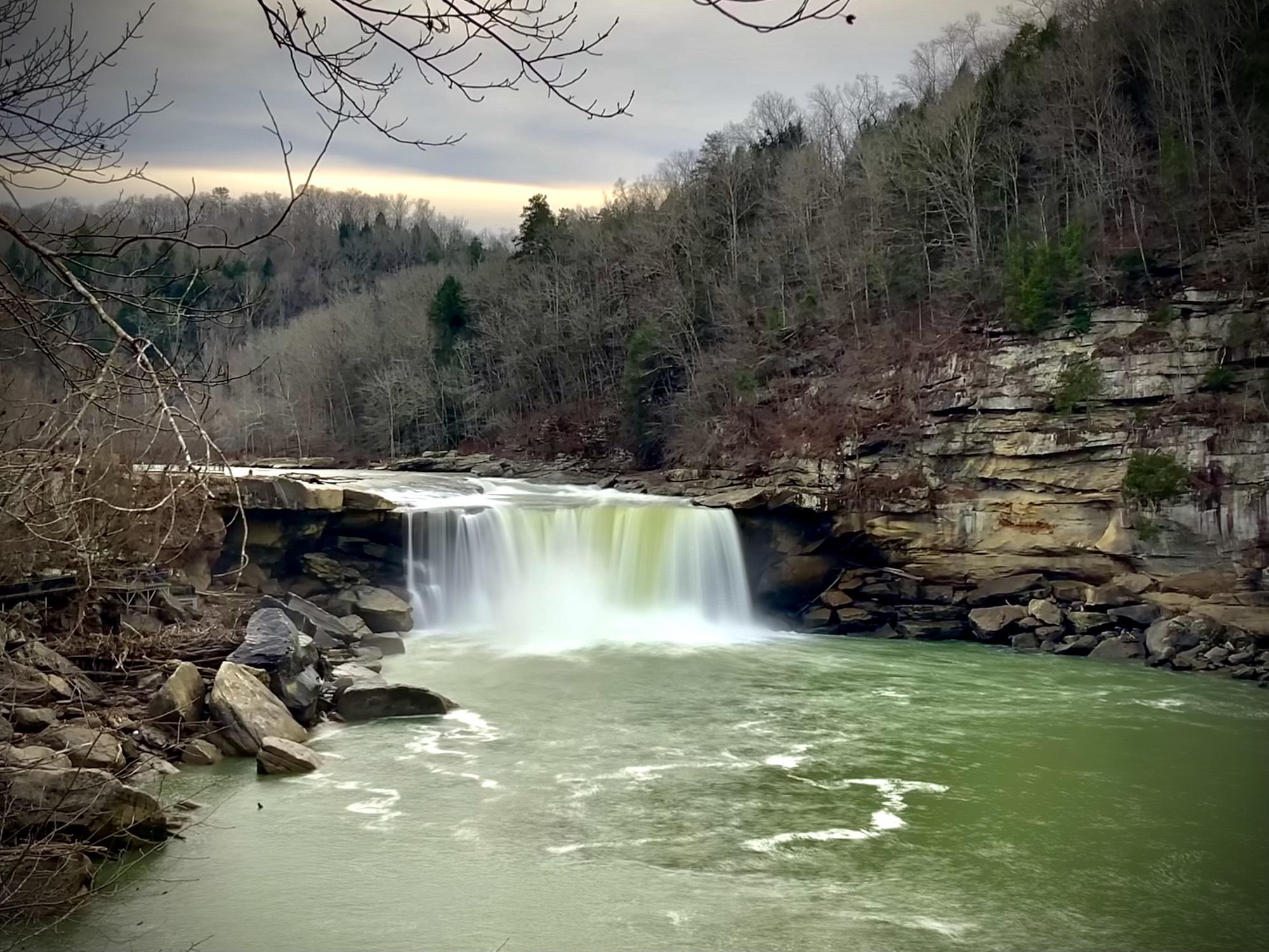 cumberland falls kentucky waterfall Majestic waterfall cascading over rocks in Red River Gorge, KY. Lush, green water below. Exploring waterfalls in Kentucky.