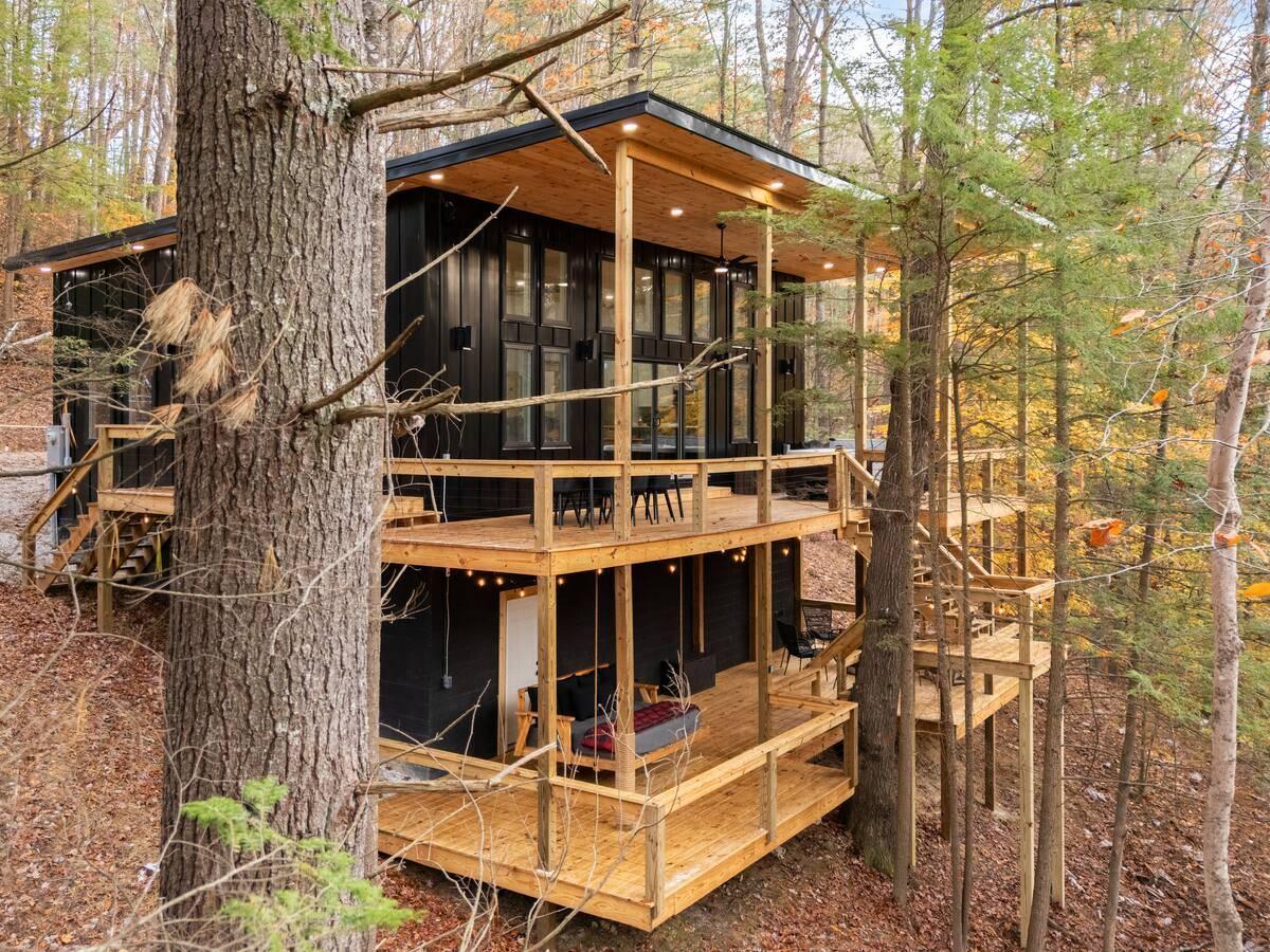 Modern Container Home Wooded Decks Modern container home with multi-level decks nestled in a wooded landscape.